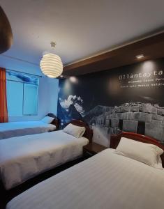 una habitación de hotel con 2 camas y un cuadro en la pared en Hostal Premier Inn, en Machu Picchu