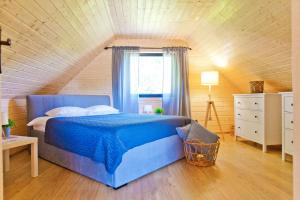 a bedroom with a blue bed and a window at Lilla House in Sasino