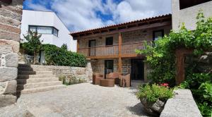 a house with a patio and stairs in front of it at Casas de Campo da Barroca in Tabosa