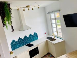 a kitchen with a counter and a tv on the wall at Precioso loft en Caión ROCHA, sobre la arena y el mar in Cayón