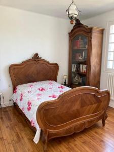 a bedroom with a wooden bed with a wooden headboard at Villa Mer, Campagne et départ de randonnées in Moëlan-sur-Mer
