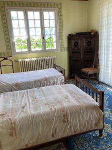 a bedroom with two beds and a window and a dresser at Villa Mer, Campagne et départ de randonnées in Moëlan-sur-Mer