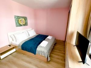 a small bedroom with a bed and a tv at Top Location !!FREE parking!! "Belle Mer" Sea Garden, Beach and Promenades in Burgas City