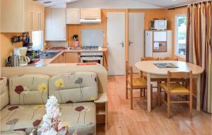 a kitchen and a living room with a table and a couch at Stunning Caravan In Hyres With Wifi And 3 Bedrooms in Hyères