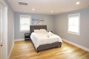 a bedroom with a bed and two windows at LakeAccess 4 Bed 3 Full Bath HOT TUB in Billerica