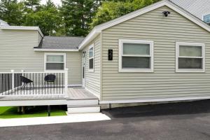a house with a wooden porch and a balcony at LakeAccess 4 Bed 3 Full Bath HOT TUB in Billerica