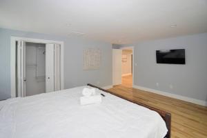 a white bedroom with a bed with a towel on it at LakeAccess 4 Bed 3 Full Bath HOT TUB in Billerica +37 photos