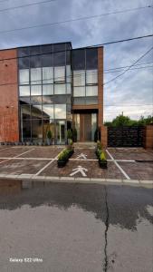 Un gran edificio de cristal con una estrella en un estacionamiento. en Studio Pop Art, en Batajnica