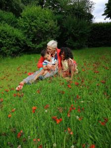 a man and two children sitting in a field of flowers at Duplex sympa Verviers in Verviers