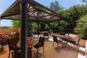 a patio with tables and chairs under a canopy at B&B Villa Zola in Capoterra
