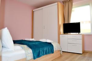 a bedroom with a bed and a flat screen tv at Top Location !!FREE parking!! "Belle Mer" Sea Garden, Beach and Promenades in Burgas City