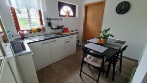 a small kitchen with a table and a sink at Apartma pri babici in Slovenj Gradec