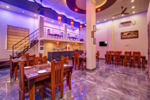 a restaurant with wooden tables and chairs and a staircase at Gracious by Vishesh Hotels & Home Stay in New Delhi