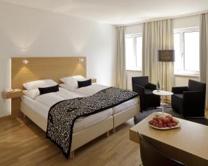 Hotel Ploberger في فيلس: غرفة فندقية بسرير كبير وطاولة