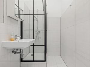 a white bathroom with a sink and a shower at SKY9 Apartments District 6 (Mariahilfer Straße) in Vienna