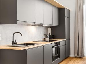 a kitchen with white cabinets and a sink at SKY9 Apartments District 6 (Mariahilfer Straße) in Vienna