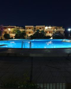 a swimming pool at night with buildings in the background at APPARTAMENTO LIDO 1 in Alghero