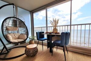 a room with a table and chairs and a large window at Magnifique Studio 2 personnes - VUE MER "La Perle de Jade" in Saint-Michel-Chef-Chef