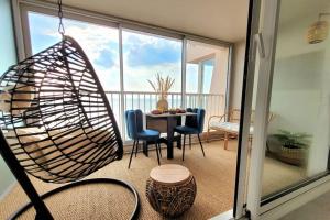a room with a balcony with a table and chairs at Magnifique Studio 2 personnes - VUE MER "La Perle de Jade" in Saint-Michel-Chef-Chef +13 photos