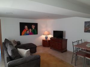 sala de estar con sofá, TV y mesa en Elizabeth Apartment, en Pedrógão Grande