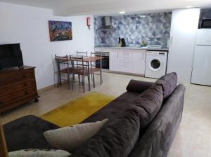 a living room with a couch and a kitchen at Elizabeth Apartment in Pedrógão Grande