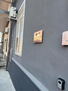 een bord aan de zijkant van een gebouw met een raam bij Holiday House Fifteen in Catania