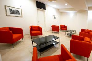 uma sala de espera com cadeiras vermelhas e uma mesa em Verdello Home em Savoca