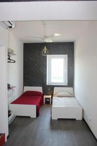 Monolocale في فيرونا: غرفة نوم بسريرين وبطانية حمراء
