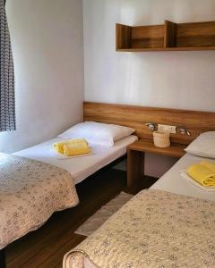 a room with two beds with yellow towels on them at Mobile Homes Aurea Maris - Kamp Dole Živogošće in Živogošće