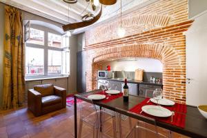 a kitchen with a table and a brick wall at Duplex climatisé dans un monument historique in Toulouse