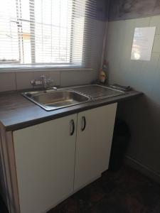 a kitchen counter with a sink and a window at The Private and Cosy Guest House 1 in Germiston