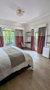 Un dormitorio con una cama grande y una lámpara de araña. en Casa Amari en Ciudad de México