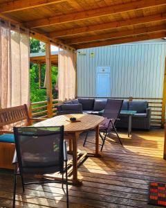 a patio with a wooden table and chairs on a deck at Mobile Homes Aurea Maris - Kamp Dole Živogošće in Živogošće