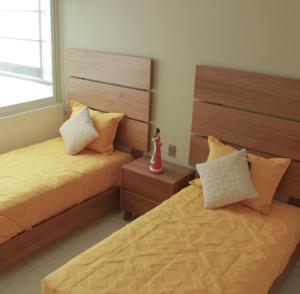 sypialnia z 2 łóżkami i oknem w obiekcie San Juan Apartament w mieście Uruapan