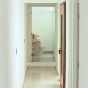 a hallway with a bathroom with a sink and a mirror at San Juan Apartament in Uruapan del Progreso