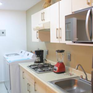 uma cozinha com um liquidificador no balcão ao lado de um lavatório em San Juan Apartament em Uruapan