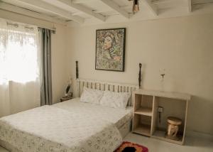 1 dormitorio con 1 cama y una foto en la pared en MASHA ARTS STUDIO en Ruhengeri