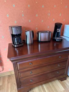 a wooden dresser with two coffee machines on top of it at Les Combes in Murat-le-Quaire