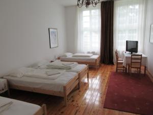 um quarto com 2 camas, uma mesa e uma televisão em Villa Deco Parádsasvár em Parádsasvár