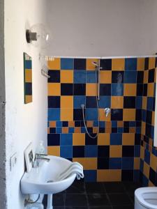 y baño con lavabo y ducha colorida de azulejos. en Buen Retiro en Portoferraio