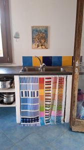 encimera de cocina con fregadero y toallas coloridas en Buen Retiro en Portoferraio