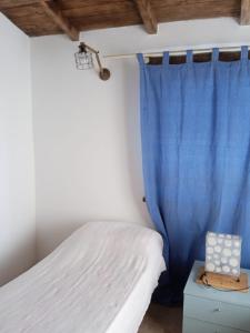 a bedroom with a bed with a blue curtain at Buen Retiro in Portoferraio