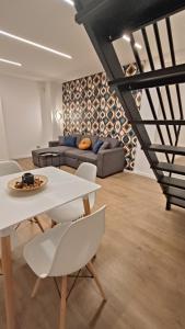 uma sala de estar com um sofá, uma mesa e cadeiras em MAISON VENTIMIGLIA 83 em Catânia