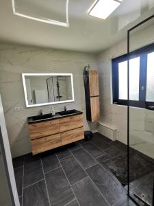 La salle de bains est pourvue d'un lavabo et d'un miroir. dans l'établissement Calme entre pins et océan, à Onesse-et-Laharie