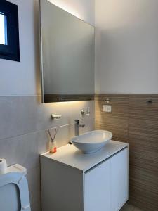 ein Badezimmer mit einem weißen Waschbecken und einem Spiegel in der Unterkunft Cbmona Suites in Villa Mercedes