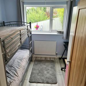 a small room with a bunk bed and a window at Benllech Beach in Benllech +19 photos