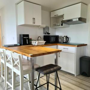 a kitchen with a wooden table and white cabinets at Benllech Beach in Benllech