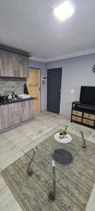 Pretoria的住宿－Cozy Little Nest，客厅设有厨房和桌子