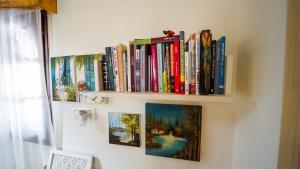 a book shelf with books on a wall at עדנת האוהבים - סוויטות קסומות ליד הכנרת עם בריכה משותפת במגדל in Migdal