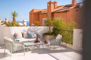 eine Terrasse mit einem Sofa, Stühlen und einem Tisch in der Unterkunft Casa Blanca in Alicante